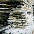 Rough antique lumber is stacked in the yard after initial organizing and tallying.