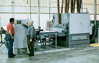 A wide-belt sander accommodates 14 planks in a single layer, sanding the top and bottom of the material at the same time.