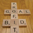 Photo of a scrabble board listing the words bid, goal and profit