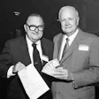 In September 1985, the American Parquet Association's Al Pollard (at left) and Virgil Hendricks sign up Lockwood Flooring as the first NWFA member.