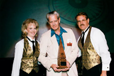Yvette Monroe and Wayne Cotton present Allan Pyne with a NWFA Floor of the Year award at the NWFA convention in Reno, Nev., in 1999.