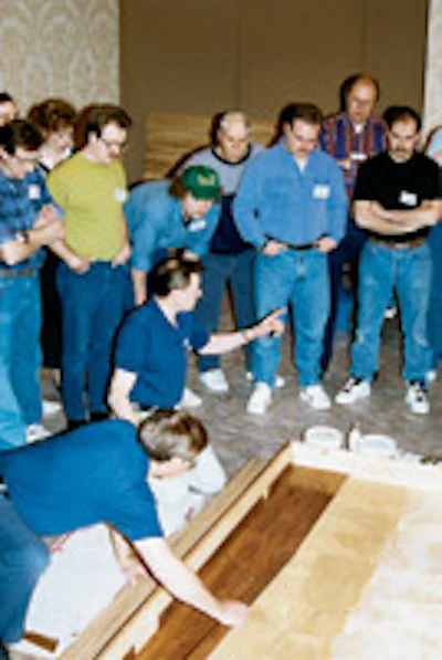 Lon Musolf (kneeling) teaches at the first National Wood Flooring Association national training school, held in St. Louis in January 1993.