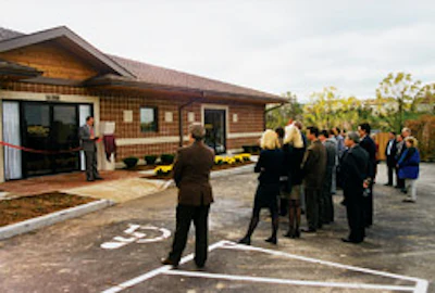 The first National Wood Flooring Association permanent headquarters is dedicated in October 1997; NWFA president John Mayers leads the ceremony.
