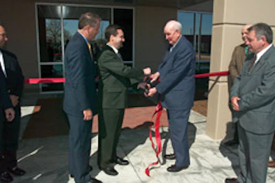 The ribbon is cutting officially opening the new National Wood Flooring Association headquarters in April 2003; (from left) Wayne Cotton, David Williams and Virgil Hendricks do the honors.