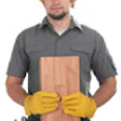 Photo of construction worker holding wooden board