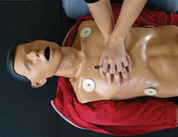 Photo of a person practicing CPR training on a dummy