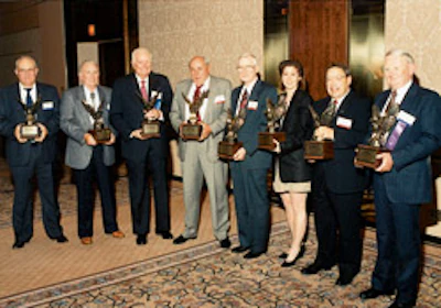 The first eight members of the National Wood Flooring Association's Hall of Fame are recognized at the 1994 convention in Dallas. (Chris Coates accepts for her father, Jack Coates.)