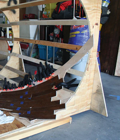 Each plank of custom-made engineered flooring was clamped into position after the three plies were glued together. When the glue dried, the planks were permanently bent. (Photos courtesy of Brent Sommerhauser)