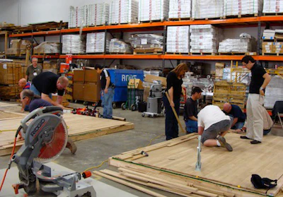 Contractors install wood flooring during a trade school held by the National Wood Flooring Association (NWFA)