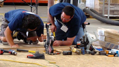 Contractors install wood flooring during a trade school held by the National Wood Flooring Association (NWFA)