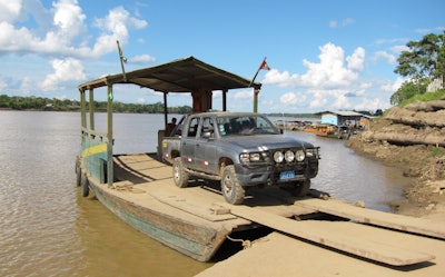 The truck, with all four wheels properly inflated and a freshly repaired spare, backs onto the ferry ...