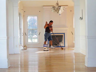 Foreman Pete DiMarco finishes a wood floor in a home in Paramus, N.J.