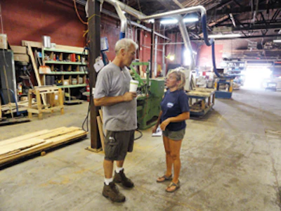 Lisa confers with Real Antique Wood Mill shop manager Mike Ciosek about a custom kitchen table he's making.