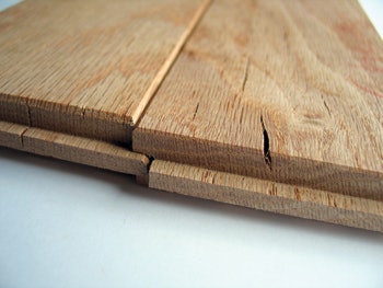 photo of checking appearing at the end pieces of unfinished wood flooring