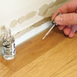 photo of finger nail polish applicator being used on wood floor