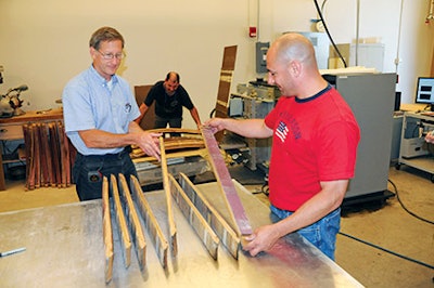 Inside the Forest Products Lab in Madison, Wis., Engineer John Hunt, left, and Jubilee Flooring's Joe Triglia inspect old wine barrel staves straightened using microwave-drying technology. (Photo courtesy of USDA's Forest Products Lab)