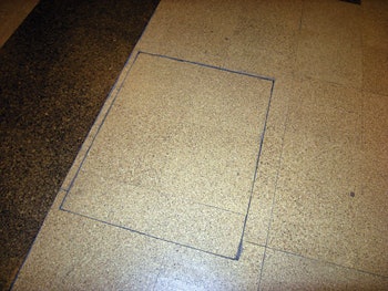 (BEFORE) Here you can see one of the panels floating on top of the channel under the floor for the computer wiring; the panels have a narrow metal border.