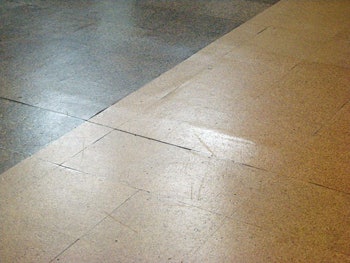 (BEFORE) This close-up shot clearly shows a ridge that is present in the subfloor; a challenge was to sand over all the irregularities without tearing apart the cork.