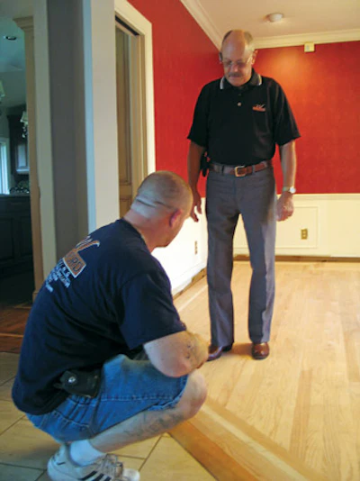 Williford inspects the clear maple border and red oak field at a repair job his company handled for a repeat customer.