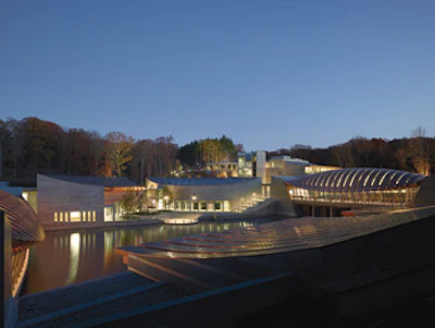 Crystal Bridges resides in a ravine about a mile from downtown Bentonville, home to Sam Walton's original Five and Dime store. Surrounding its half dozen connected pavilions are ponds, streams and stands of hickory, tulip, rosewood, dogwood and evergreens.