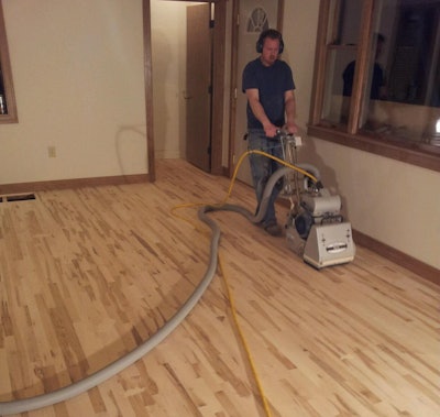 Bob Kalma Sanding the Dwyers new maple wood floors on his own time. Photo Courtesy of Matt Thrane.