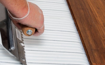 photo of someone applying wood flooring adhesive