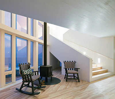 The inn is made up of two intersecting volumes, forming an X. The floors follow the length of the two legs and intersect here.