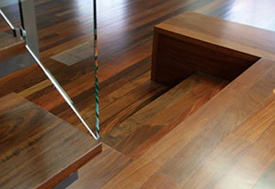 Ipé's varying color and natural warmth draws eyes to the floor throughout the home. Left, a bathroom mirror is exposed by closing a floor-to-ceiling panel.