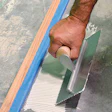 photo of someone gluing down flooring to backer a board