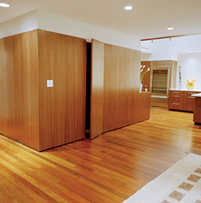 On the main level, adjacent to the kitchen and family room, walnut clads an island of washrooms and storage areas. Below, the home's occupants appreciate the home's natural and artificial light.
