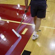 photo of someone finishing an athletic wood floor