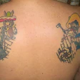 Manny Navarro shows off the wood flooring tattoos on his back.