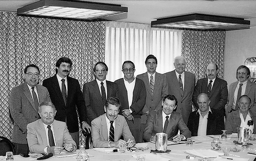 At this meeting in St. Louis in December 1985, the National Wood Flooring Association was officially created. Seen are (seated, left to right): Jack Wilcox, H.G. Roane Company; Ralph Singer, Diamond W Supply; Lon Musolf, Lon Musolf Distributing; Roland Holder, Gentry & Holder Floors; Harold Reid, Trinity Floor Company; (standing, left to right): Gary Reynolds, Galleher Hardwoods; Steve Brown, Swift-Brown Distributors; Art Pedicini, Geysir Sales Corporation; Jack Coates, Golden State Flooring; Richard Steeneck, Hoboken Wood Floors; Virgil Hendricks, Mid-West Floor Company; Eldon Robbins, Mid-West Floor Company; and Keijo Hyvonen, Kelly-Goodwin Company.