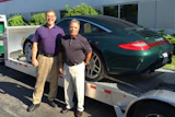 Al Futscher (left) and Tony Roberto of CDC Distributors stand in front of a Porsche 911, which they won the right to use for one month this summer.