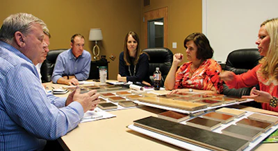 Hart and three other Ambassador Floor employees, including president Taylor, discuss flooring products during a quarterly meeting with one of the company's biggest suppliers.