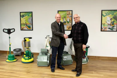 Karl Lägler, owner of Eugen Lägler GmbH (left), and Bruce Whisenhunt, former owner of Palo Duro Hardwoods, seal Lägler's acquisition of Palo Duro with a handshake during Lägler's recent grand opening in Denver.