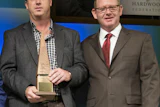 Steve Welch (left) accepts the 2015 Wood Floor of the Year–Best CNC/Laser Cut award from NWFA Chairman Jeff Fairbanks.