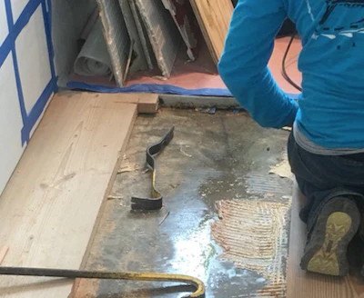 A wet slab showing a leak under a wood floor.