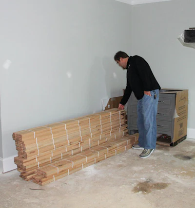 Gilbert checks the wood flooring upon delivery for quality issues.