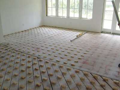 On this job, we used plywood blocks precut to different depths at our shop to fill in the low spots in these subfloors prior to installing a double layer of plywood as the final subfloor.