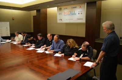 Representatives from nine underlayment/substrate manufacturers sign the MOU.