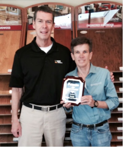 Jeff Ellis of Horizon Forest Products presents Genia Smith, owner of Accent Hardwood, with an Outstanding Sales award.