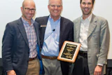 Jeff Jaeckle, president of Jaeckle Distributors (left) and Torrey Jaeckle, vice president of Jaeckle Distributors (right) accept the 2016 President’s Award from President of Mannington Residential Ed Duncan.