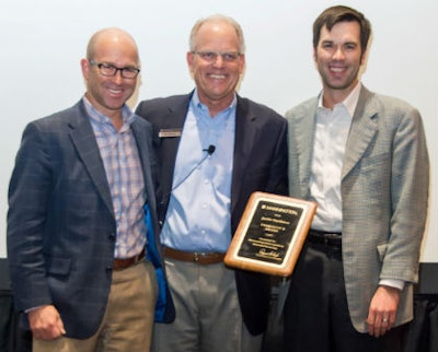 Jeff Jaeckle, president of Jaeckle Distributors (left) and Torrey Jaeckle, vice president of Jaeckle Distributors (right) accept the 2016 President’s Award from President of Mannington Residential Ed Duncan.