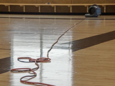 Fans blow to dry out the floor of a basketball court at the California State University Fullerton. Photo by Ken Steinhardt.