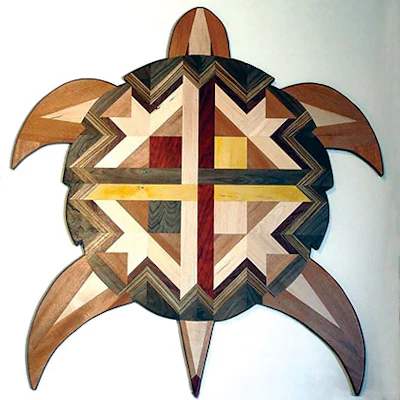 This sea turtle wall hanging, commissioned by someone in California who saw my turtle floor, measures 8 feet across and incorporates the colors of the medicine wheel by using walnut for black, padauk for red, maple for white and maple with aniline dye for the yellow. I intertwined the four colors in the middle to represent the four colors of people coming together. The turtle also has zebrawood, cocobolo and cherry.