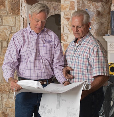 The author (left) and project manager Jim Lotspeich of Builders West Inc. review plans after floods destroyed the home's existing wood floors.