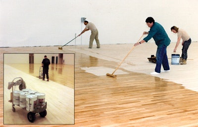 In this photo, a crew from Albany, N.Y.-based J.J. Curran & Son Inc. uses lambswool applicators to apply the original formulation of Trophy Gym Finish by Hillyard, which was an epoxy-based gym finish, at Niskayuna High School. 'We used to apply it using multiple guys using lambswool,' says Seamus Curran, project manager and chief estimator for J.J. Curran. Their current technique can be seen in the photo below. 'Nowadays we apply finish on gyms using Hillyard's Multi-Flo, which pumps out finish using an electronic pump. We went from four or more guys applying to one guy on the machine and one guy cutting in at the walls. We're still using a lot of oil-based finish, but now it's all 350 VOC.'