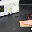A device records the voltage produced as Assistant Professor Xudong Wang presses his hand on an electricity-producing floor prototype.