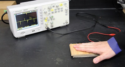 A device records the voltage produced as Assistant Professor Xudong Wang presses his hand on an electricity-producing floor prototype.